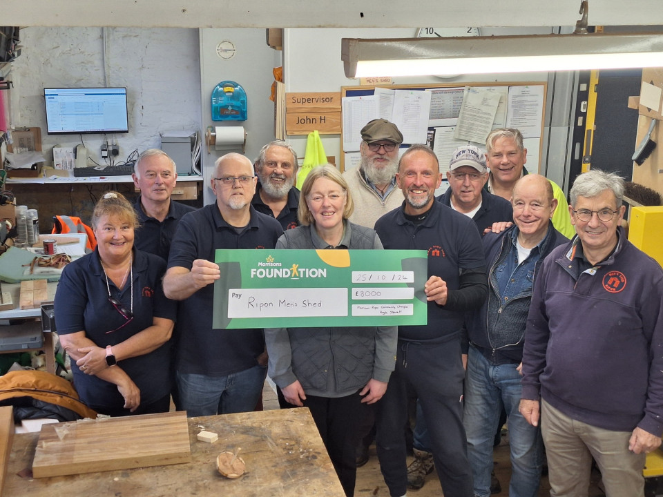 Group of colleagues holding a large £8000 cheque for Ripon Men's Shed