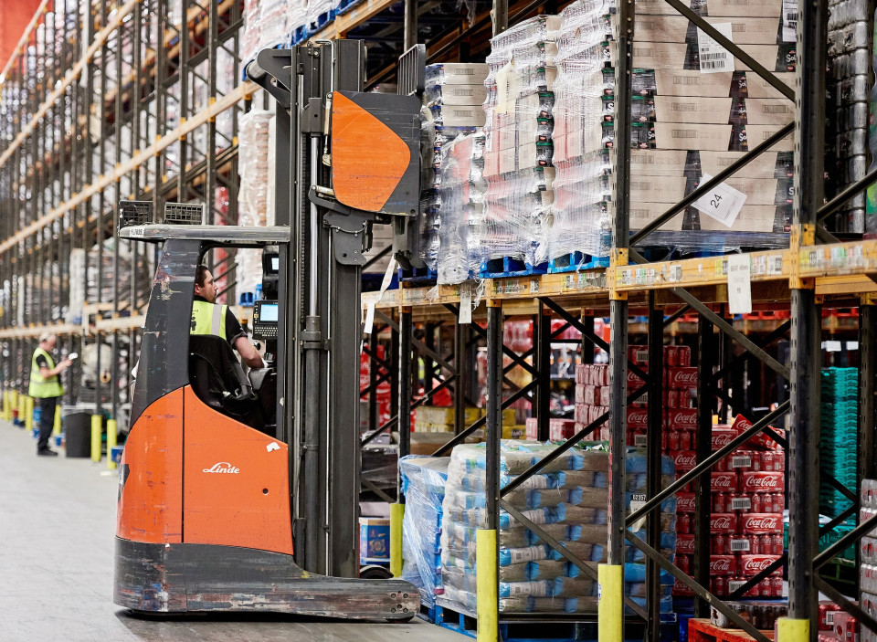 Logistics colleagues using forklift to move boxes of product