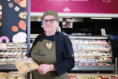 Bakery colleague holding a pack of bread rolls