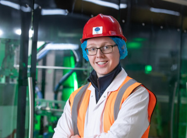 Colleague in protective clothing smiling in factory